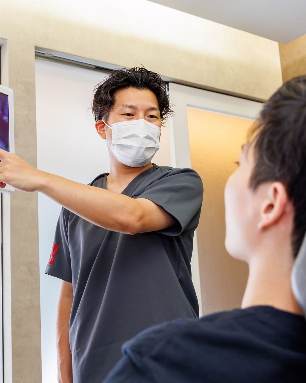 モニターを指しながら説明する歯科医師